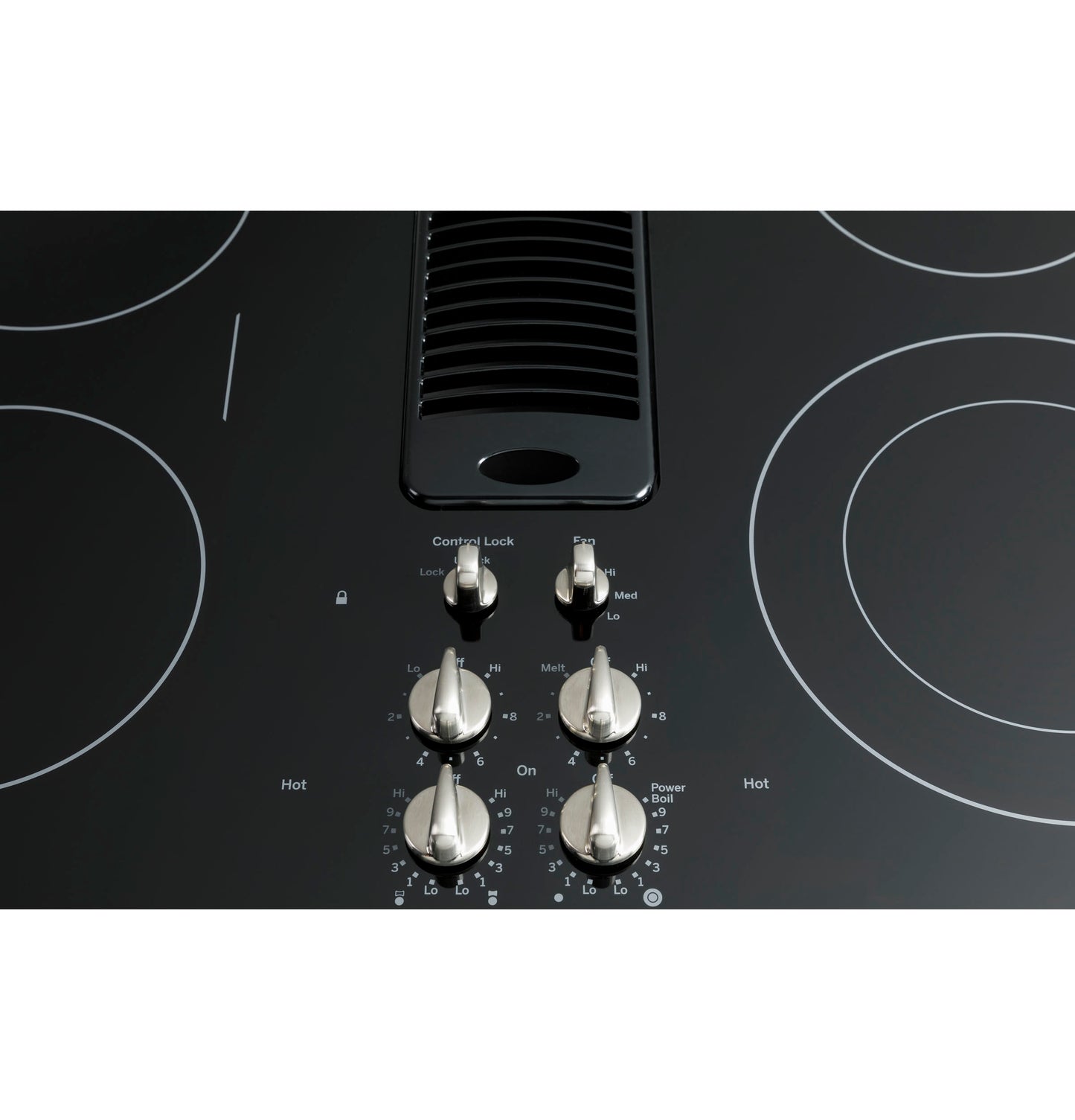 Close-up of stainless steel control knobs and downdraft vent on black glass GE Profile 30" electric cooktop