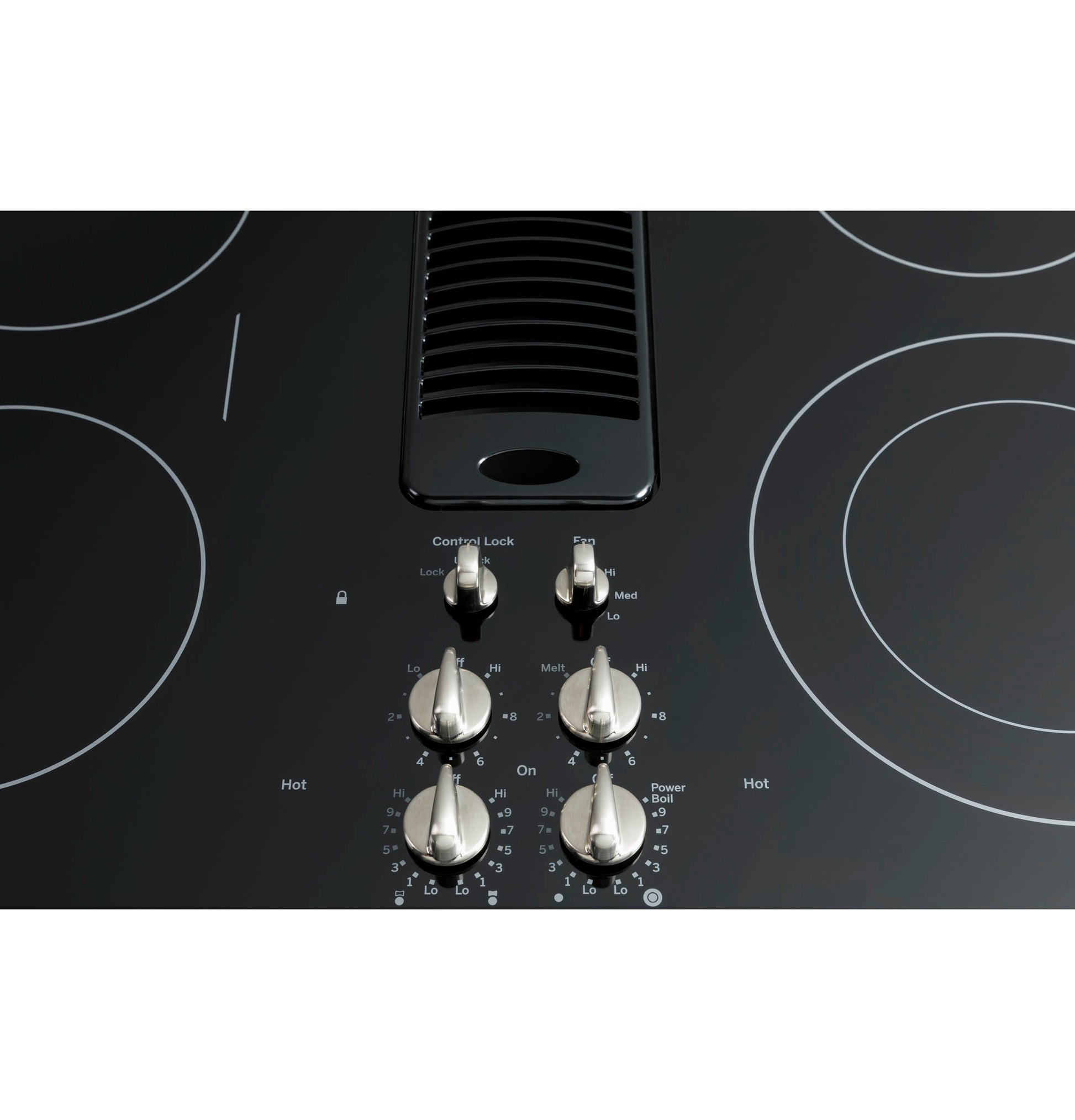 Close-up of stainless steel control knobs and downdraft vent on black glass GE Profile 30" electric cooktop