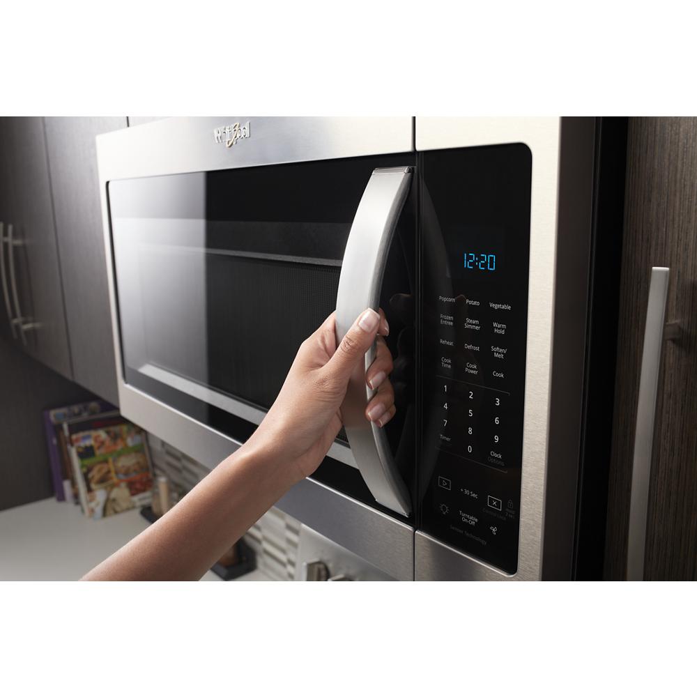 Hand opening stainless steel steam microwave with digital sensor controls mounted in kitchen cabinetry for home improvement.