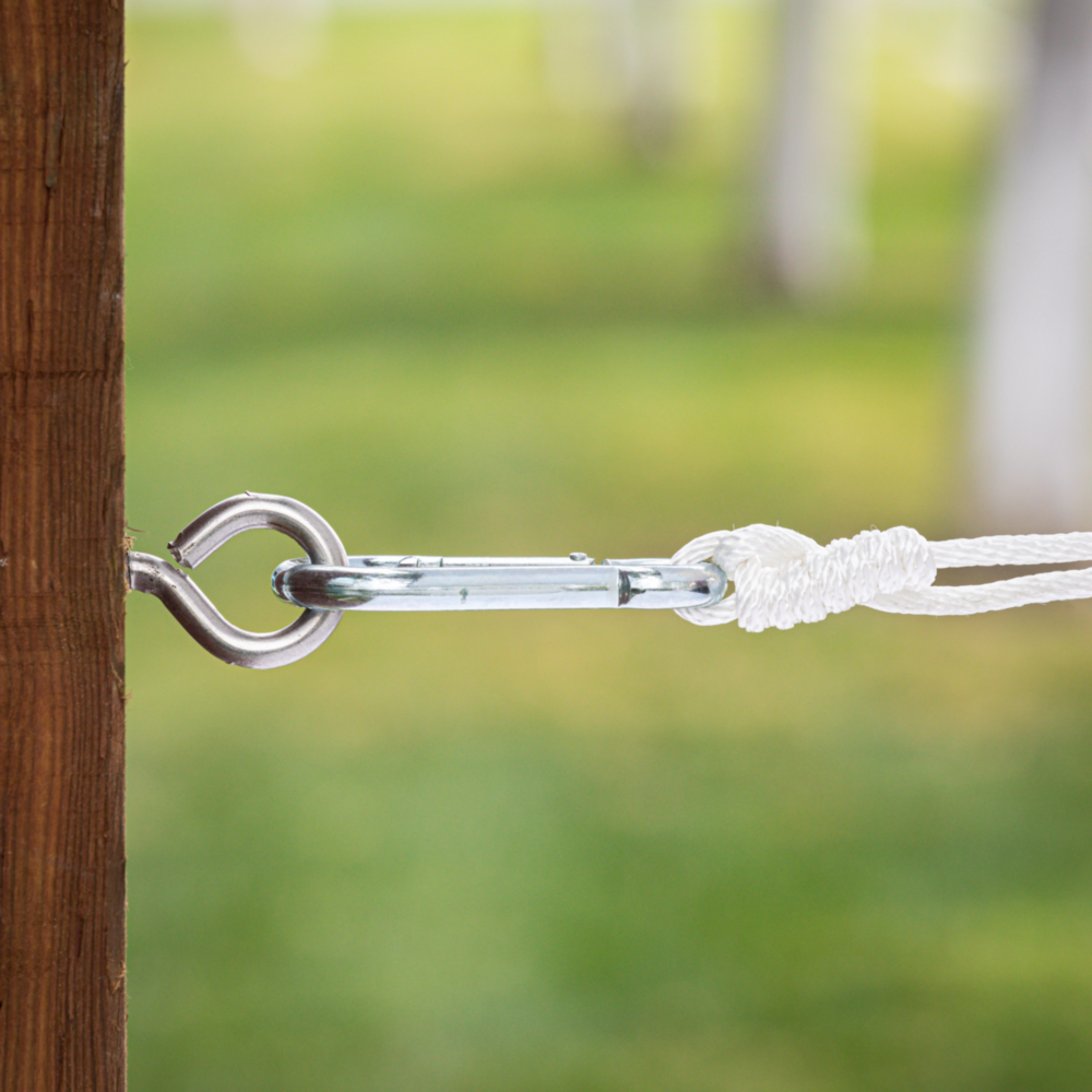 Stainless steel large screw eye with carabiner clip securing braided rope to wooden post for hardware and home improvement projects