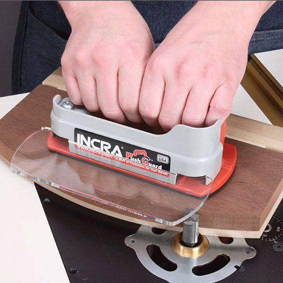 Hands gripping push block with clear debris shield on woodworking table in Under $50 home improvement tools collection
