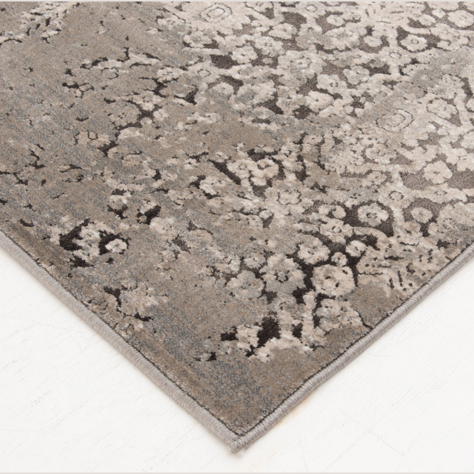 Area rug corner with intricate brown and cream mottled pattern showcasing textured artistic design for stylish decor