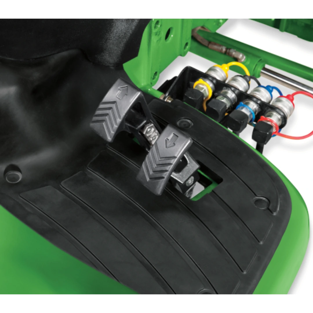 Close-up view of control foot pedals with directional arrows and hydraulic connectors on a green John Deere 3046R Compact Tractor at Hartville Hardware.