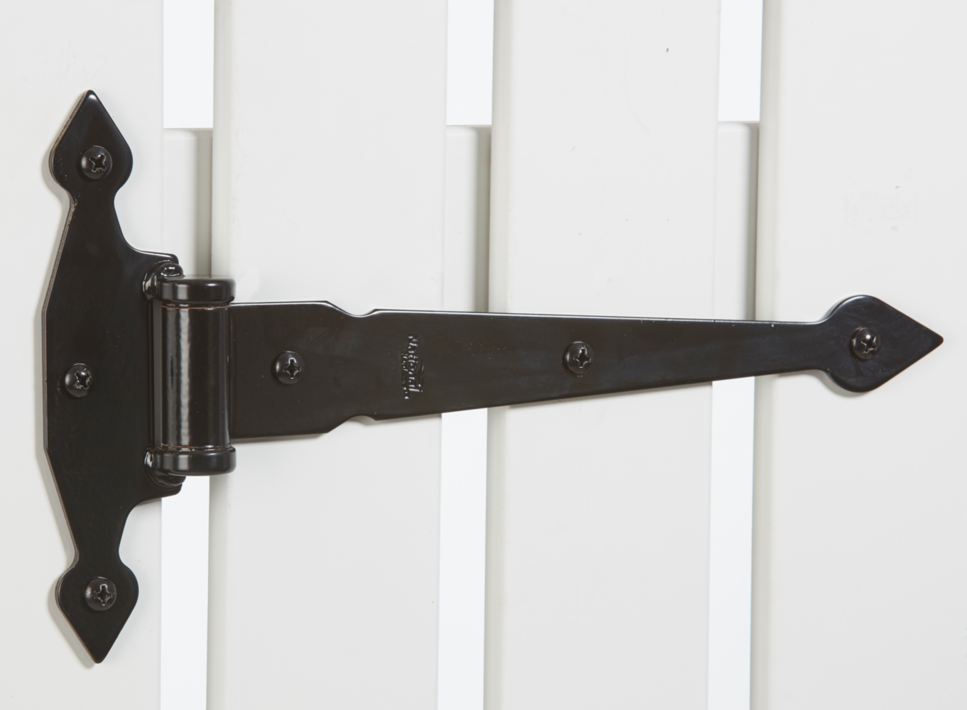 Black spear-style heavy-duty gate hinge mounted on white wooden gate for outdoor home improvement use