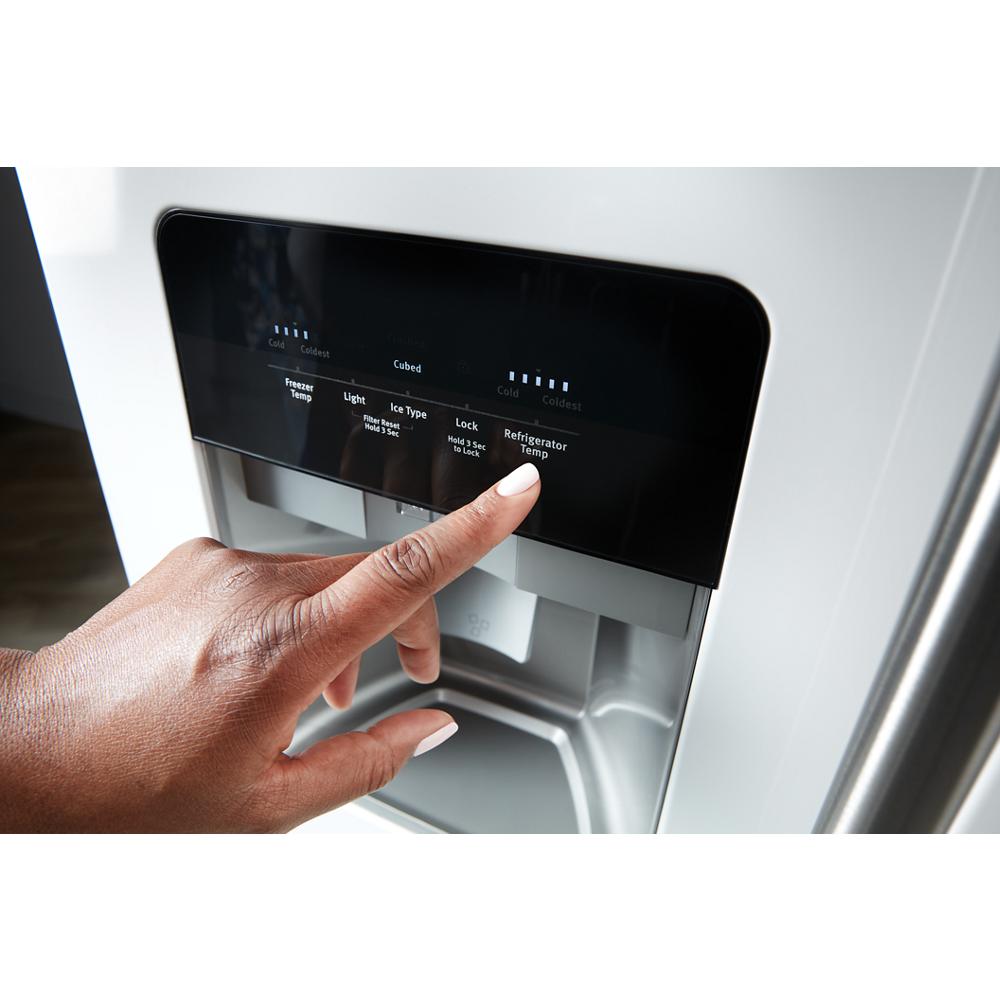 Hand adjusting temperature settings on water and ice dispenser control panel of side-by-side refrigerator in Appliances collection
