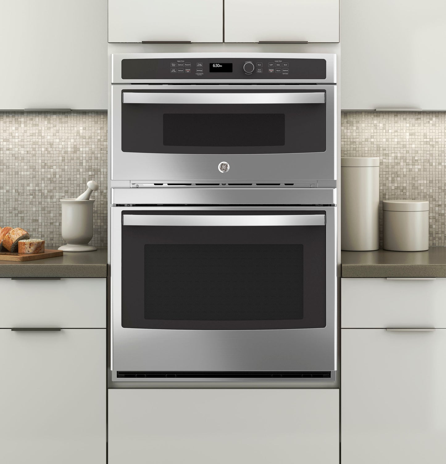Built-in stainless steel combination double wall oven installed in modern kitchen with neutral cabinetry and backsplash
