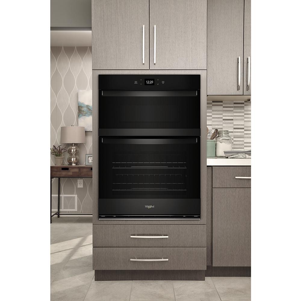 Built-in black combo wall oven with digital display and sleek modern cabinetry in kitchen appliances collection