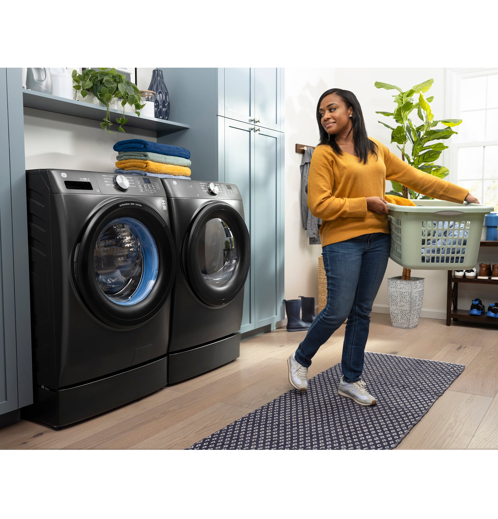 Modern laundry room with dark gray front load washer and dryer raised on a 7-inch riser in Appliance Parts & Accessories collection