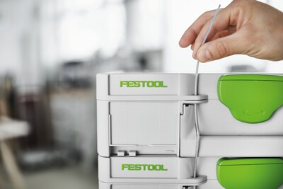 Stacked light gray and green Festool Systainer3 tool storage boxes with secure locking lids for workshop organization