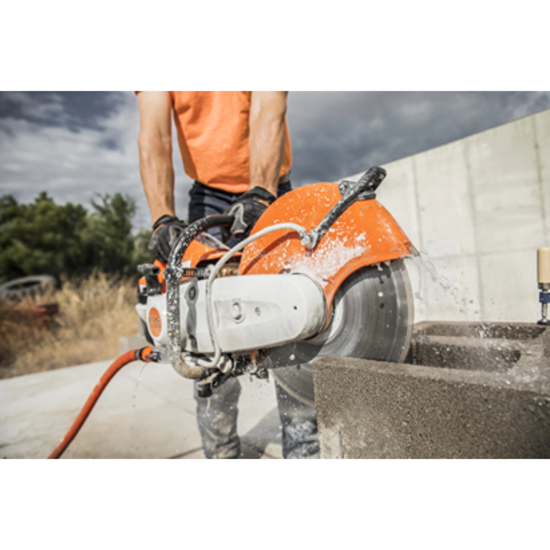 Orange and white handheld Cutquick power cutter with water-cooled blade cutting concrete block for tools and home improvement tasks