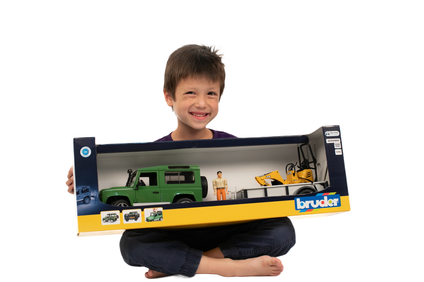 Smiling child holding Bruder Toys Land Rover Defender with JCB Micro Excavator & Trailer from Vehicles & Remote Controlled Toys collection