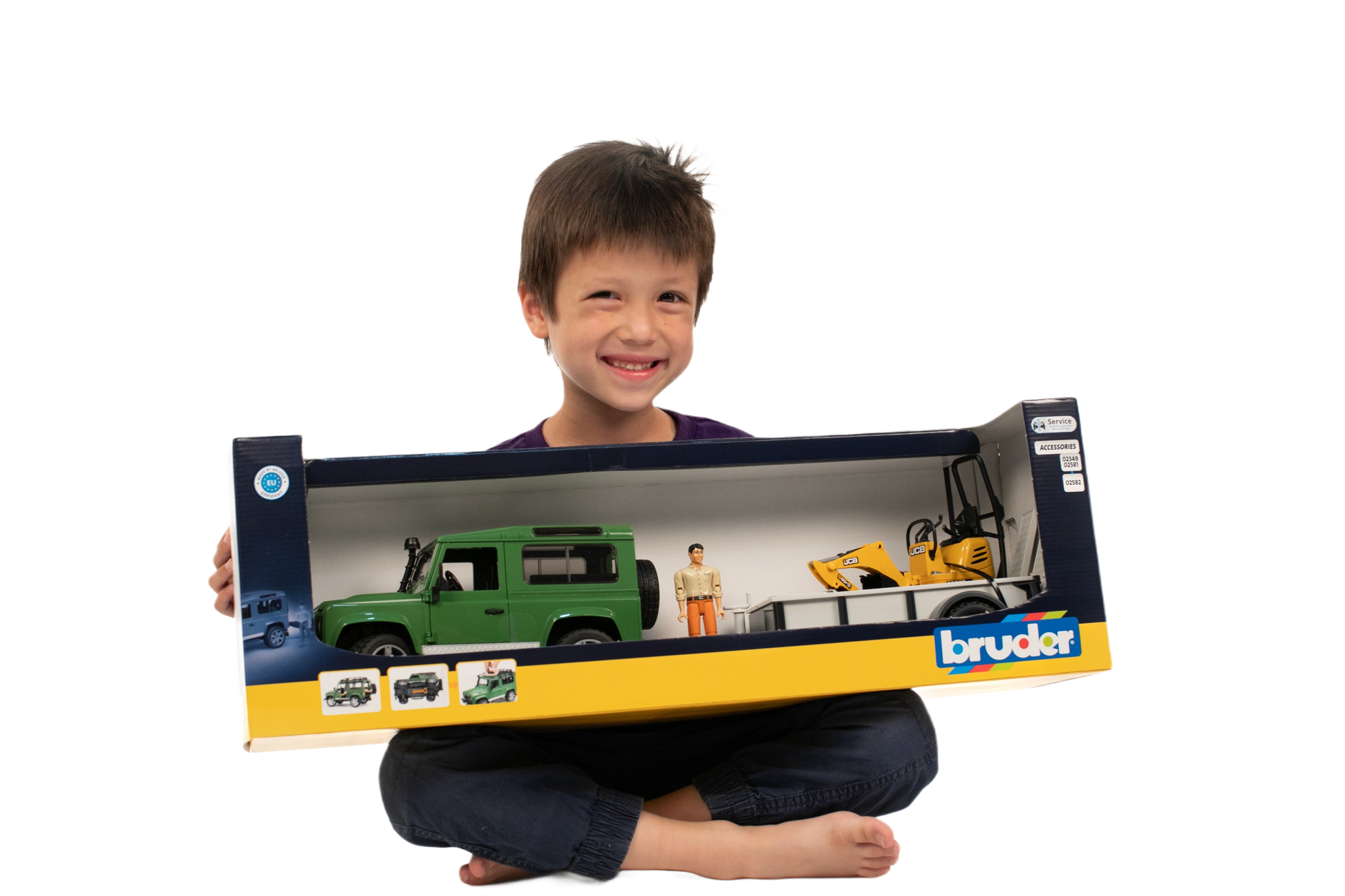 Smiling child holding Bruder Toys Land Rover Defender with JCB Micro Excavator & Trailer from Vehicles & Remote Controlled Toys collection