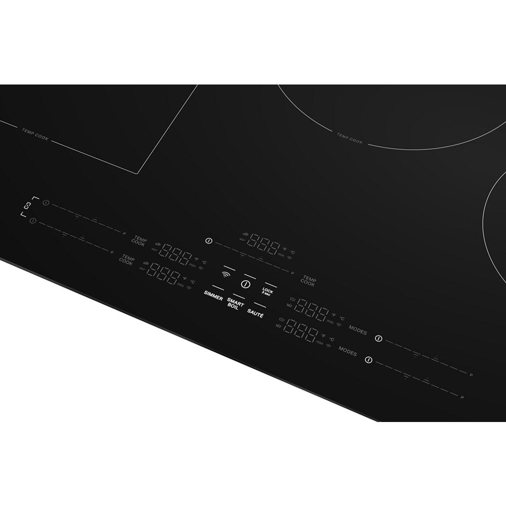 Close-up of digital touch controls on sleek black induction cooktop with five cooking zones and mode options visible