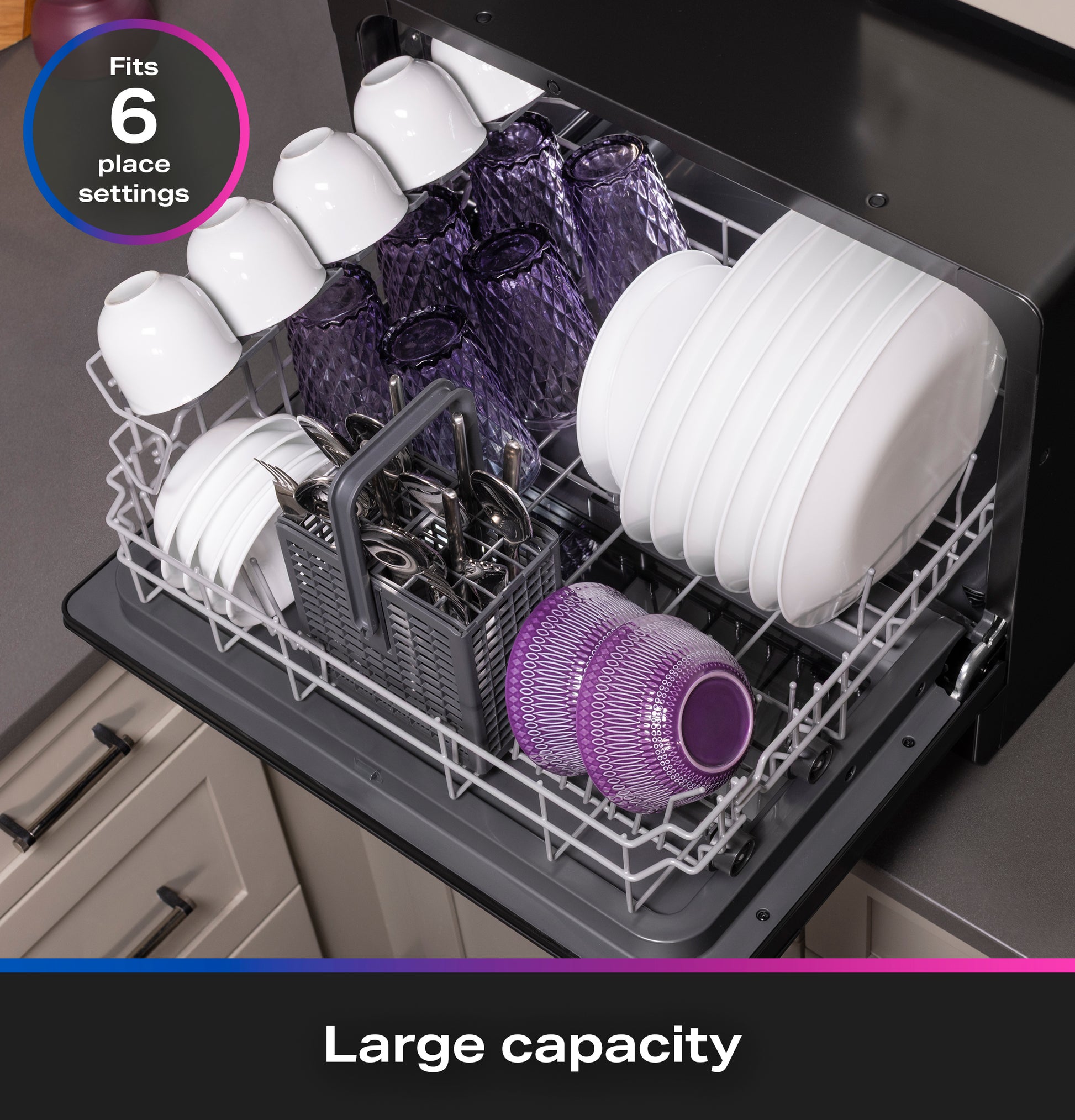 Open compact dishwasher loaded with plates, glasses, and cutlery showing large capacity for six place settings on countertop