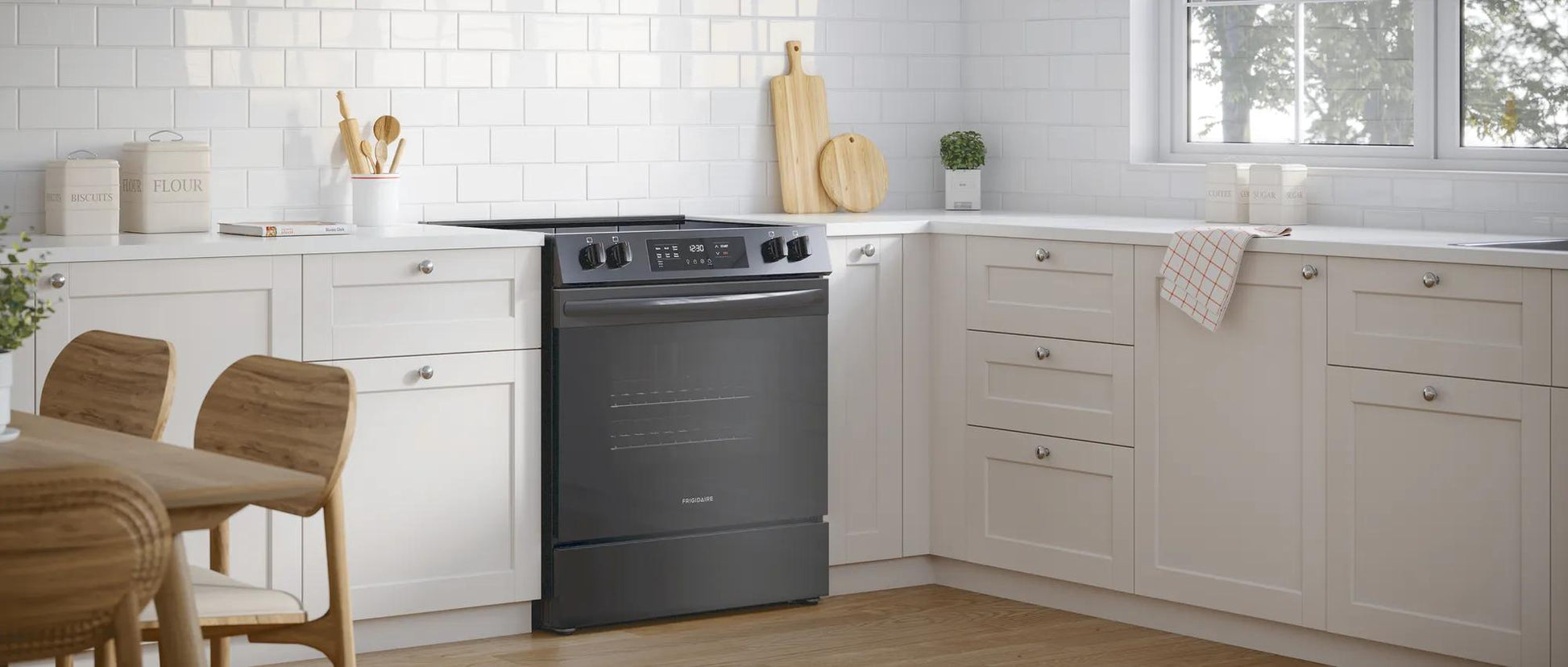 Black front control electric range installed in bright kitchen with white cabinets and wood accents, part of home appliances collection