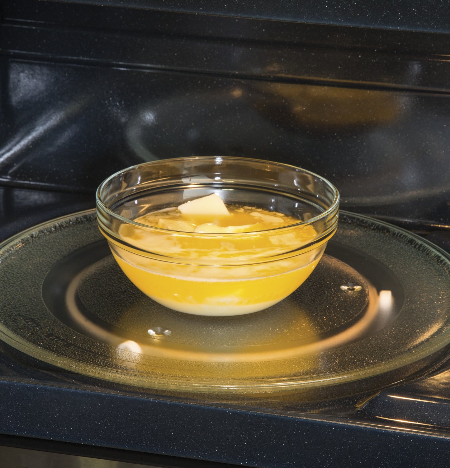 Glass bowl with butter melting inside a microwave with a rotating glass tray in Kitchen & Kitchenware collections