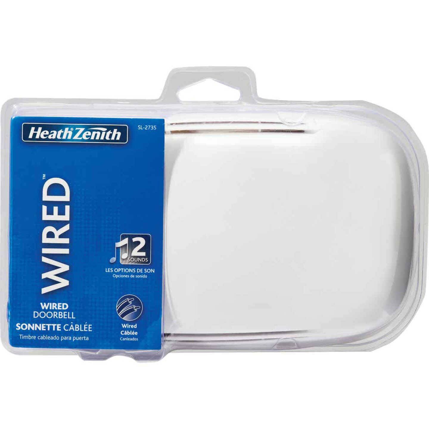 Clear plastic packaging containing a white round wired doorbell with blue label for home improvement use