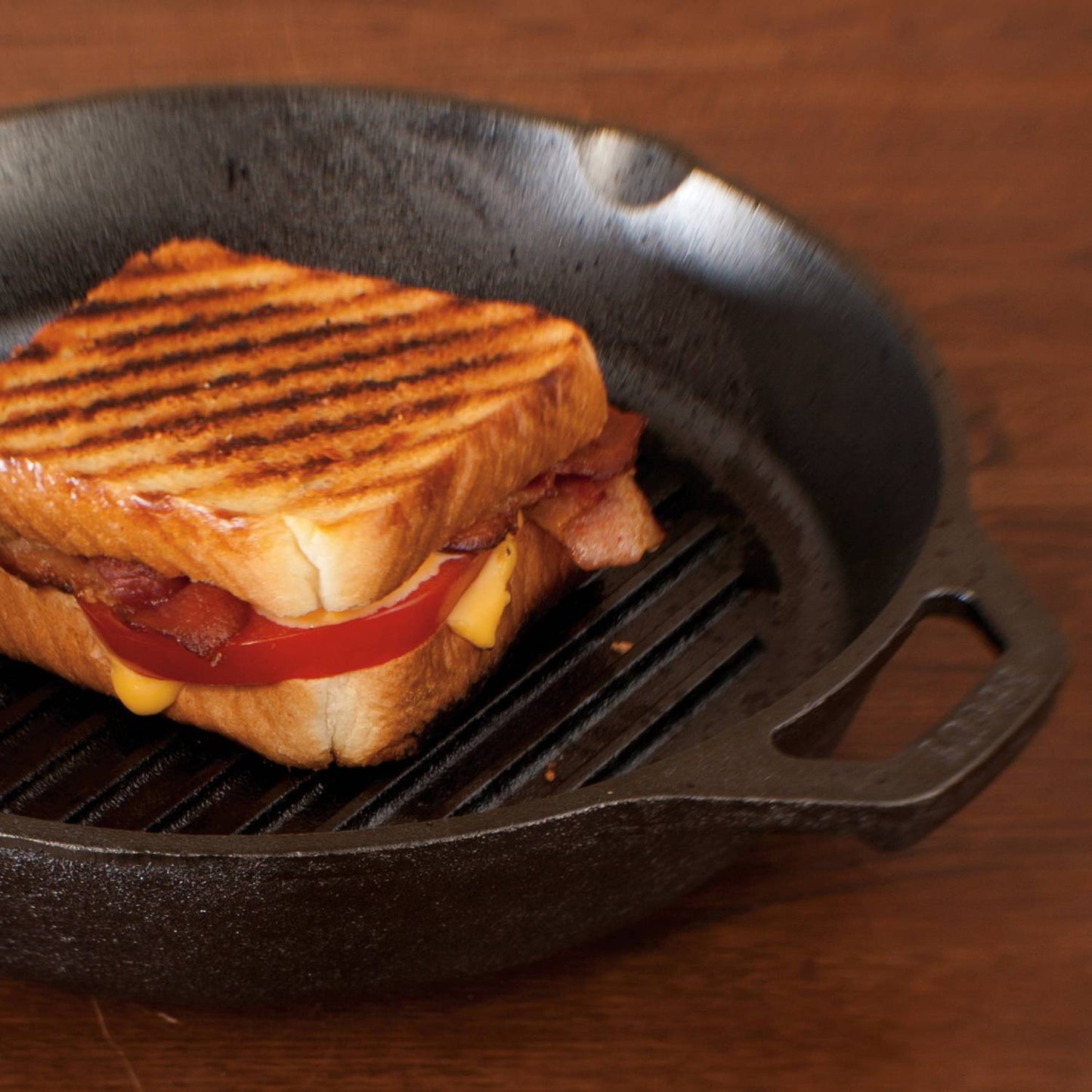 Cast iron skillet grill pan with ridged surface cooking toasted sandwich with bacon, tomato, and cheese kitchenware under $50