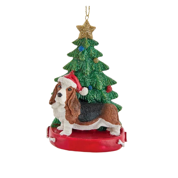 Bassett hound ornament wearing Santa hat in front of decorated Christmas tree for holiday decor collections