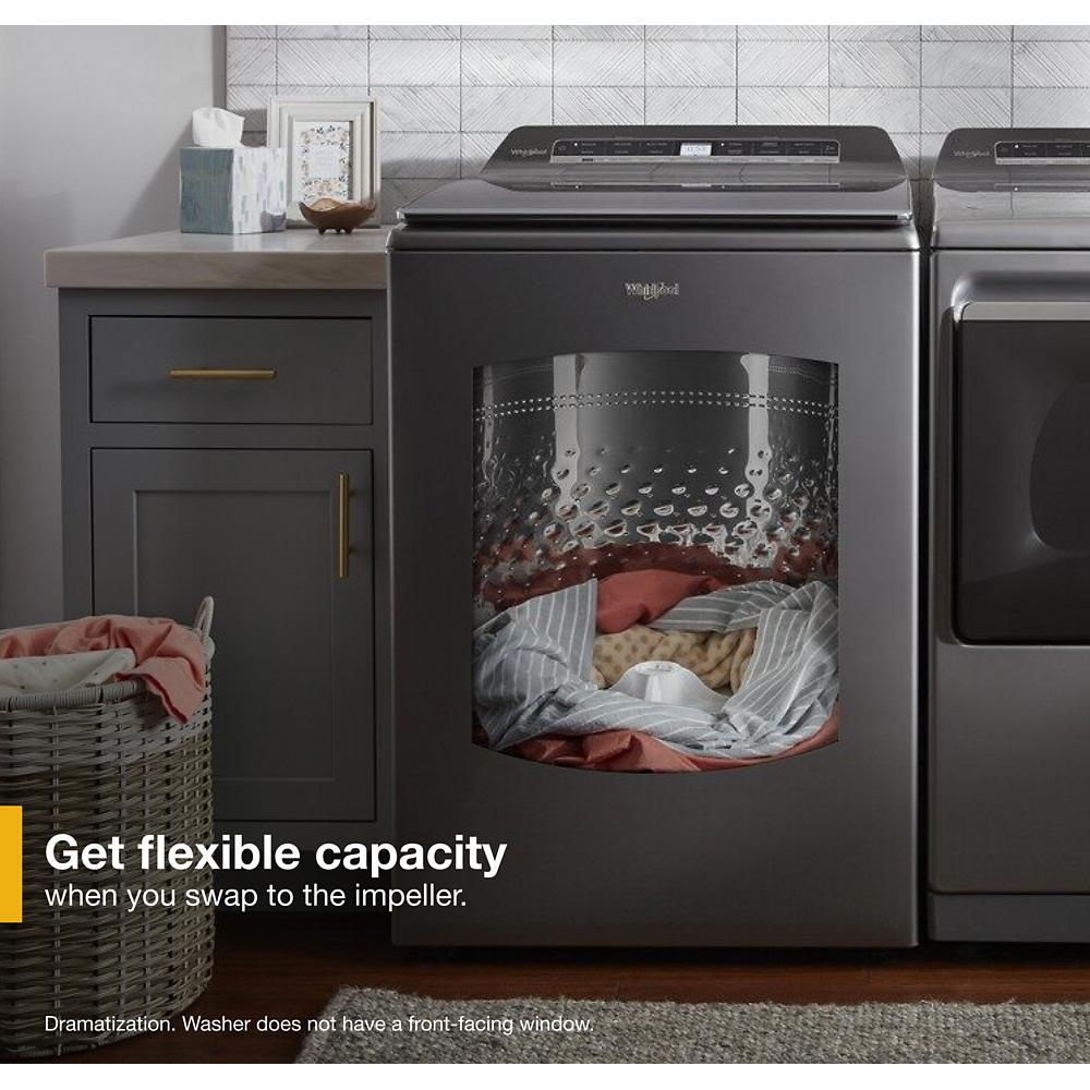 Gray top load washer in modern laundry room with open lid showing drum and assorted laundry inside