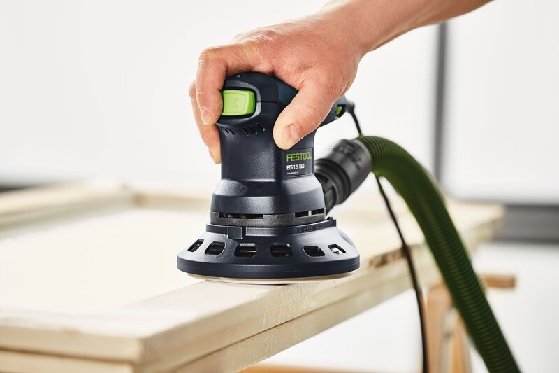 Corded electric handheld detail sander in use on wood surface with dust extraction hose attached in woodworking tools collection