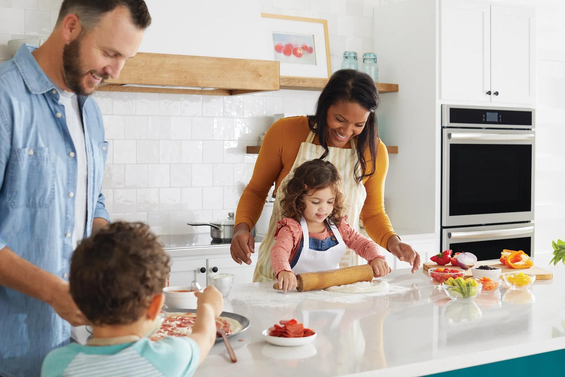 Family preparing food together in modern kitchen with built-in double electric wall oven from Appliances collection