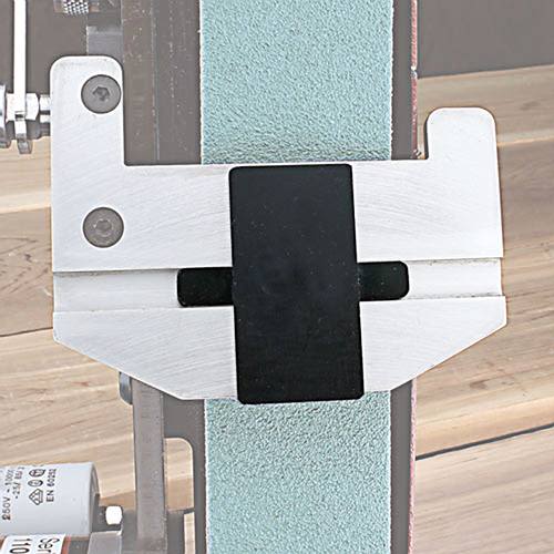Metal jig clamp with black adjustable grip mounted on green sanding belt for wood carving tool sharpening use