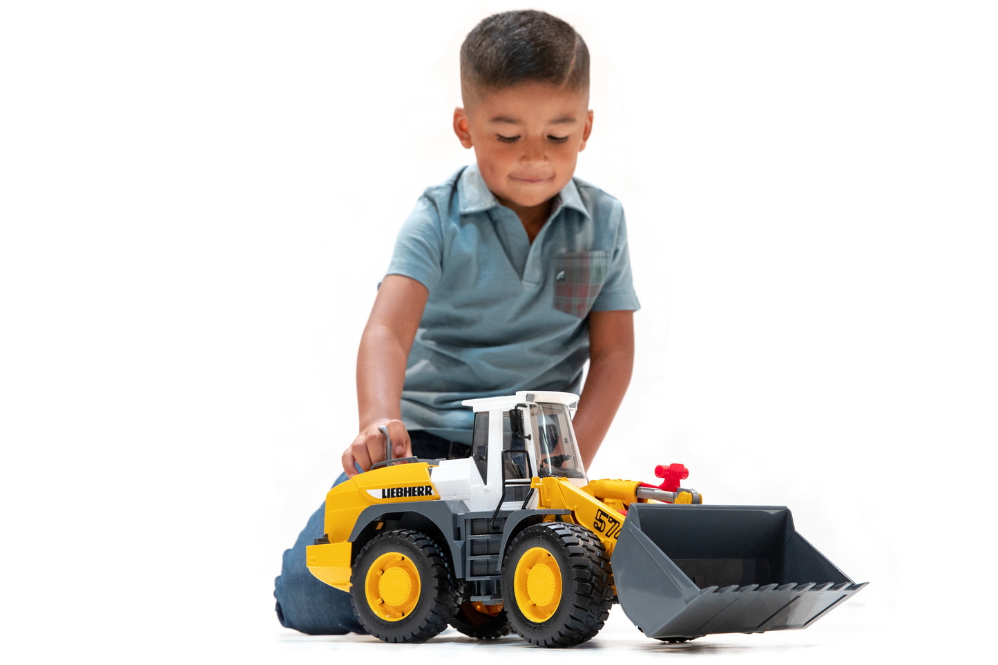 Child playing with yellow Bruder Liebherr loader toy with large tilting shovel in Vehicles & Remote Controlled Toys collection