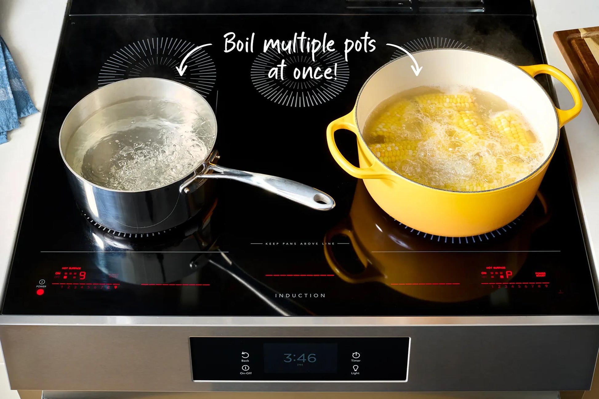 Two pots boiling on black induction cooktop with digital controls from Ranges & Cooktops collection