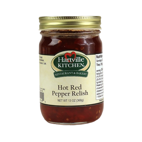 Glass jar of hot red pepper relish with gold metal lid and beige Hartville Kitchen label for kitchen pantry use