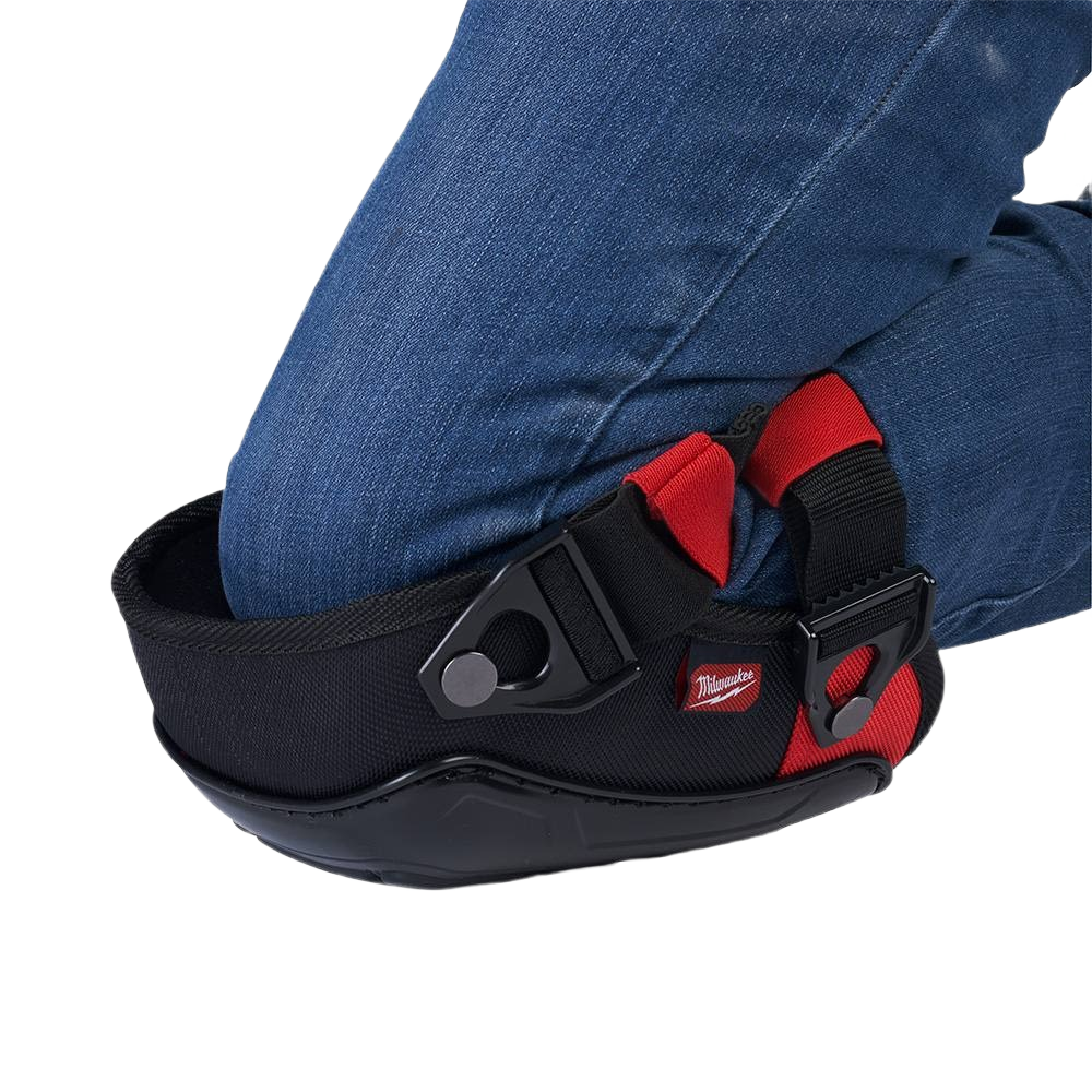Kneeling person wearing black and red performance knee pads with reinforced padding for safety and comfort in hardware tasks