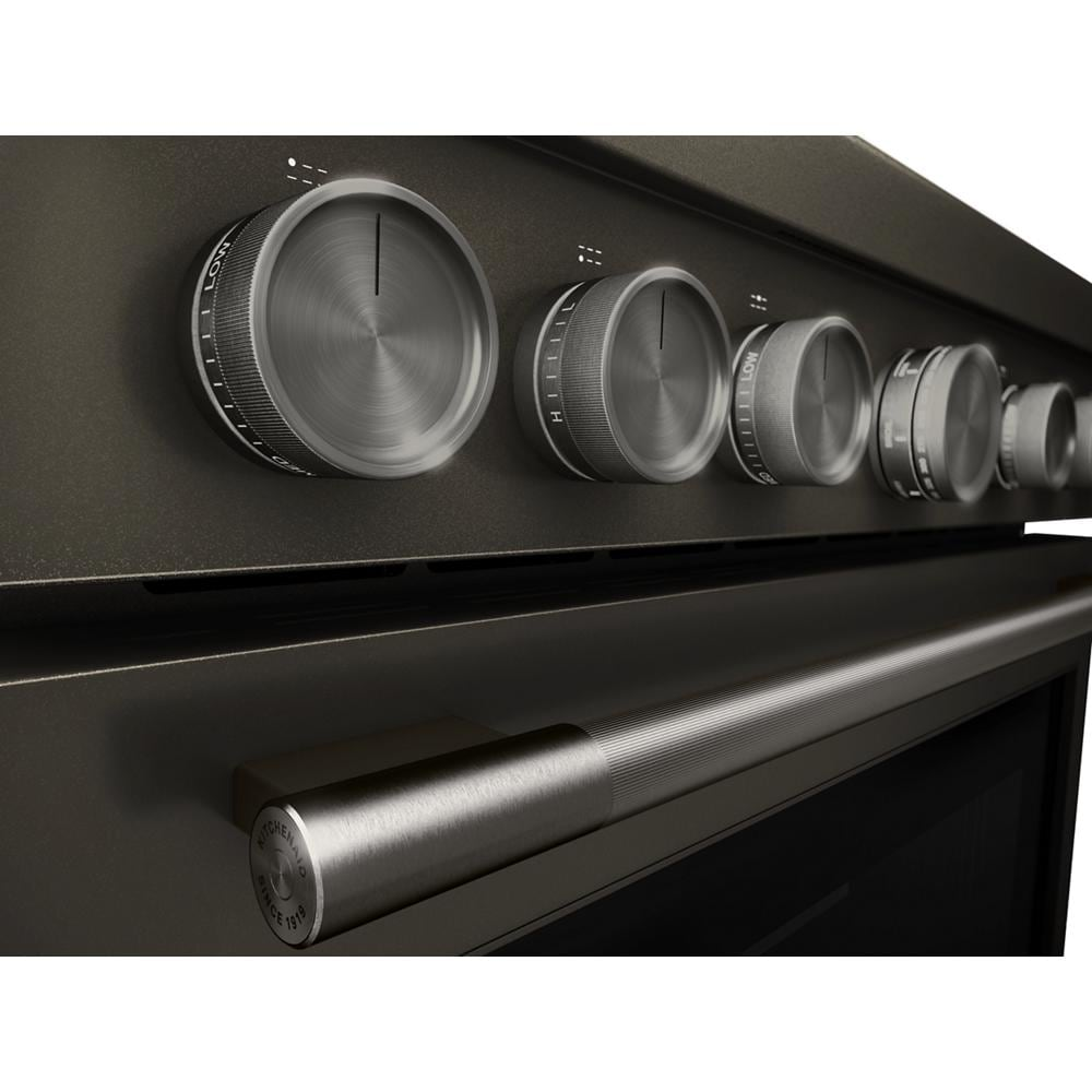 Close-up of stainless steel control knobs and handle on 36-inch KitchenAid commercial-style dual fuel range