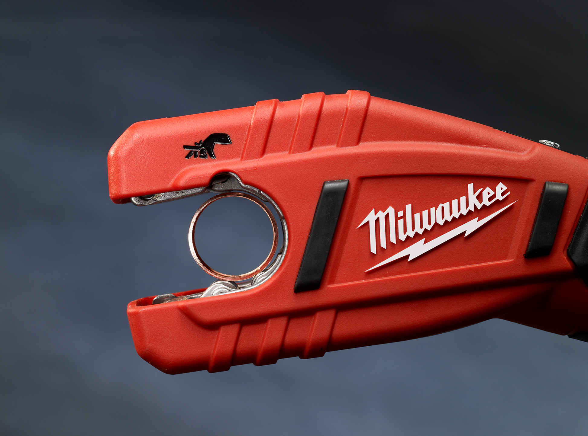 Red cordless copper tubing cutter tool designed for plumbing and pipe cutting in tight spaces by Milwaukee brand