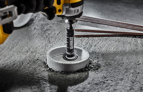 Compact drill attachment cutting a clean circular hole in concrete for tools and home improvement use