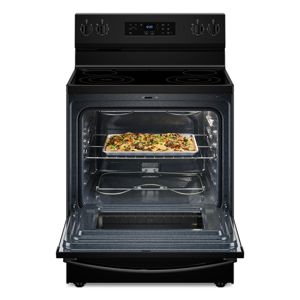 Black electric range with open self-clean oven door showing a casserole baking inside, part of kitchen appliances collection