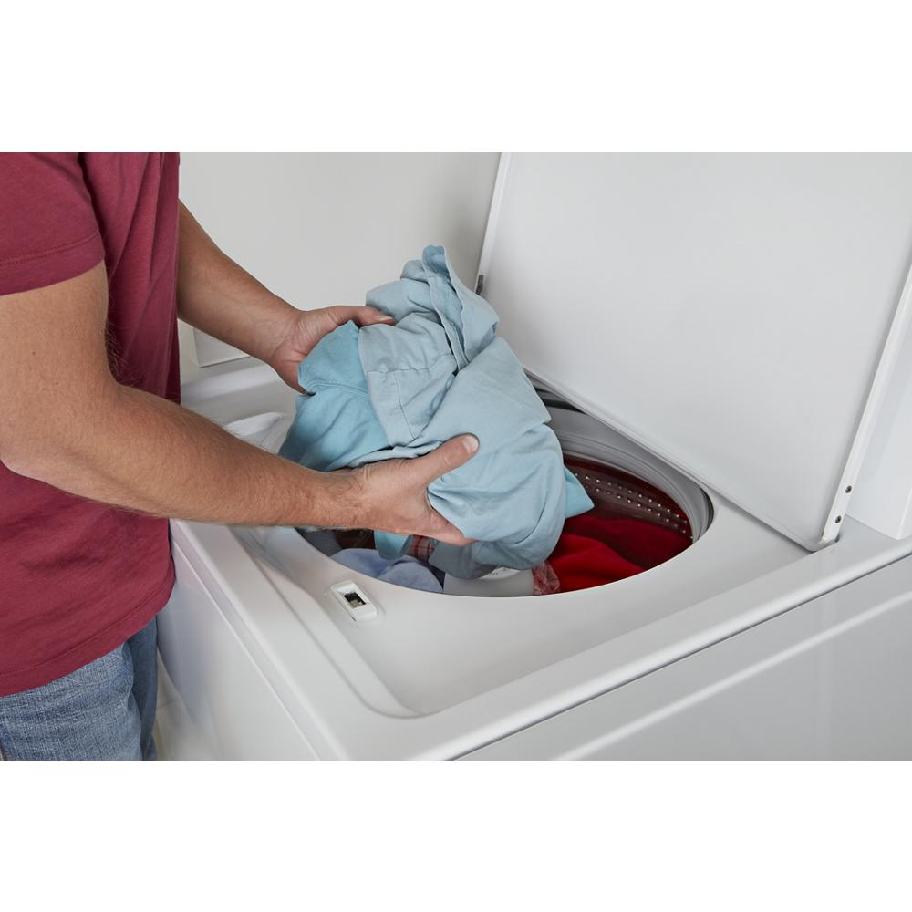 Person loading light blue and red laundry into a white large capacity top load washer from washers collection