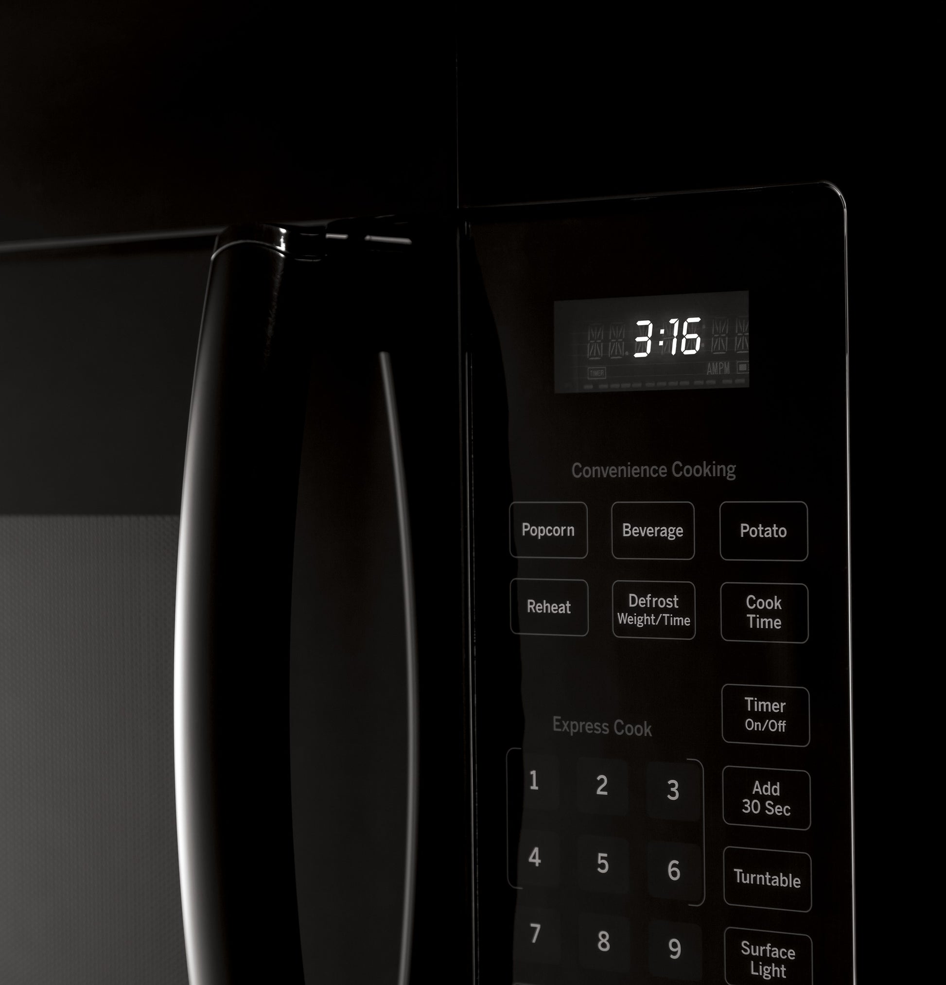 Close-up of black over-the-range microwave control panel with digital clock and preset cooking buttons from appliances collection