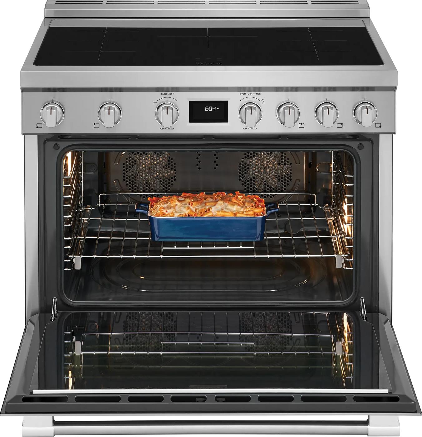 Open stainless steel freestanding induction range with digital display, control knobs, and casserole inside oven in appliances collection