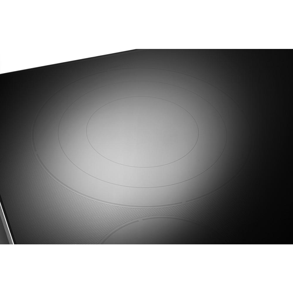 Close-up of smooth black electric cooktop glass surface with faint concentric heating element outlines for kitchen use