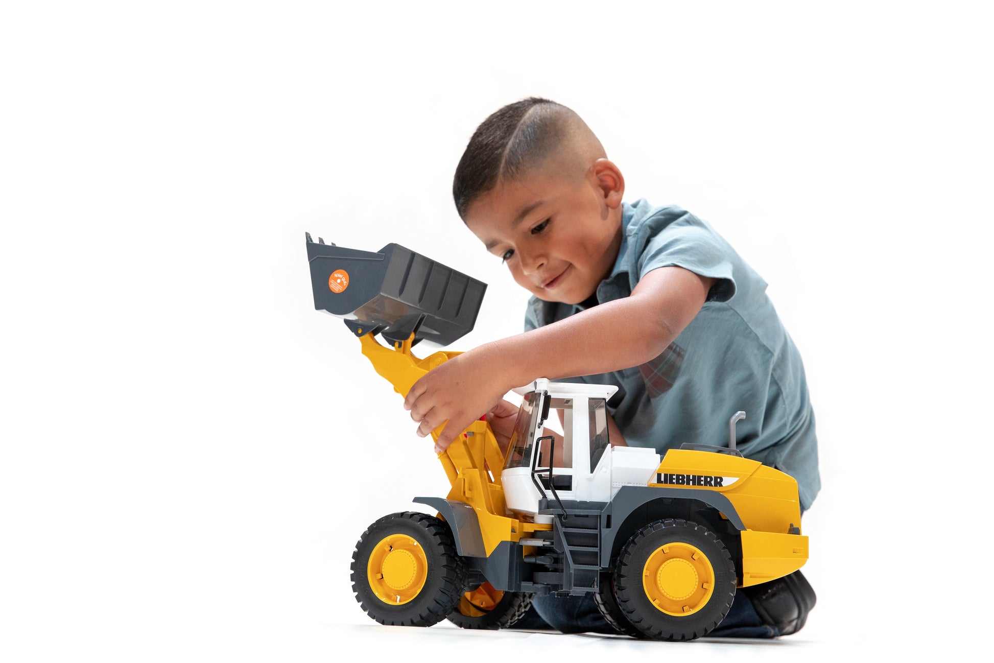Child playing with yellow Bruder Liebherr articulated road loader toy in Vehicles & Remote Controlled Toys collection