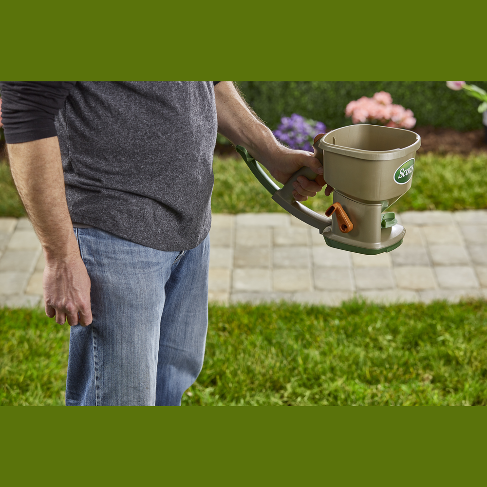 Handheld spreader with ergonomic handle and crank for efficient lawn care in garden tools and outdoor collections under $50