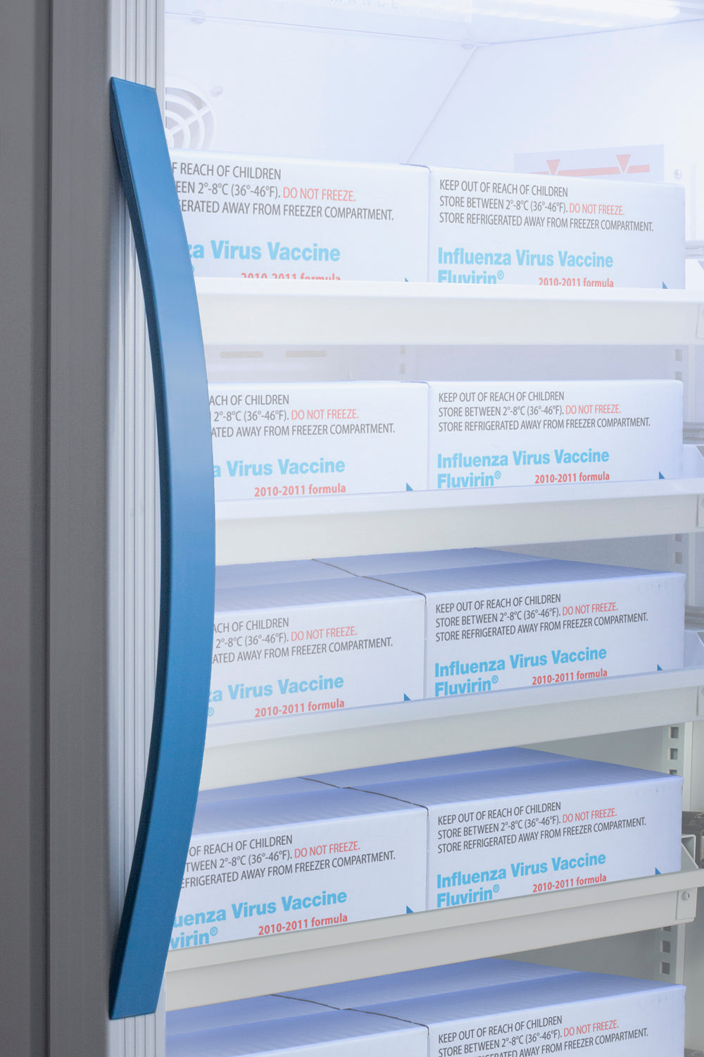Boxes of influenza virus vaccine stored on shelves inside a refrigerator in appliances and kitchenware collections