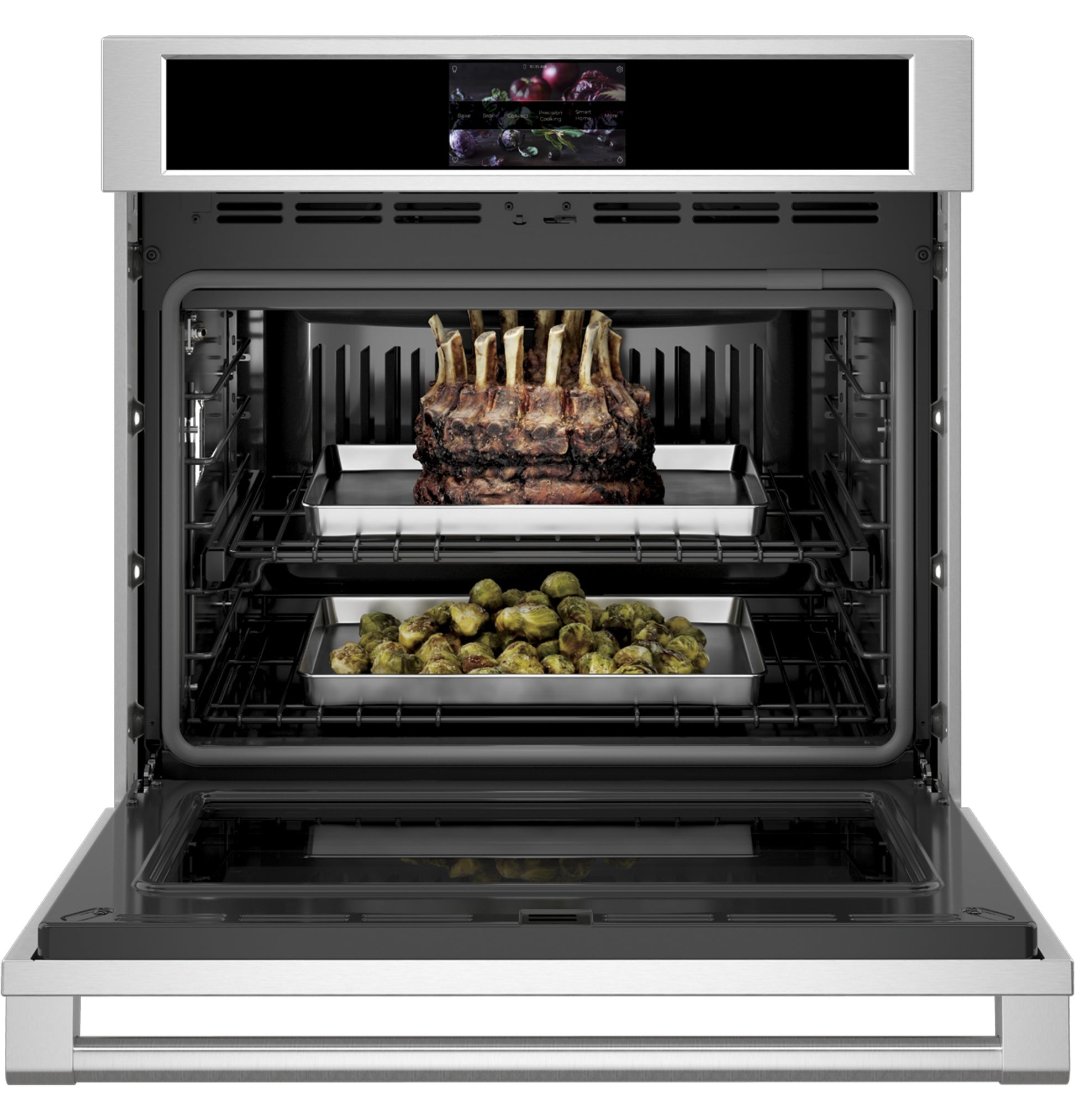 Open stainless steel wall oven with digital display and two trays cooking meat and roasted vegetables inside