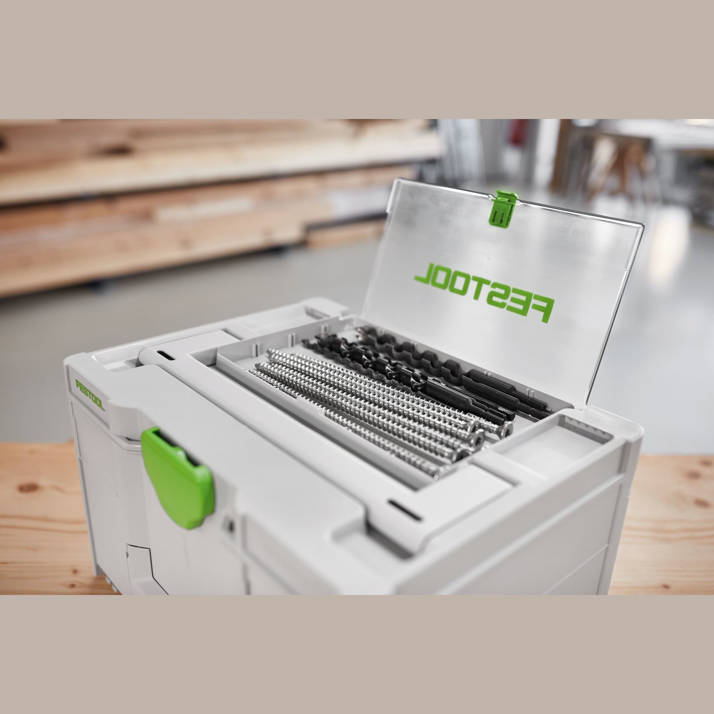 White and green modular tool storage box with transparent lid compartment holding drill bits for workshop use