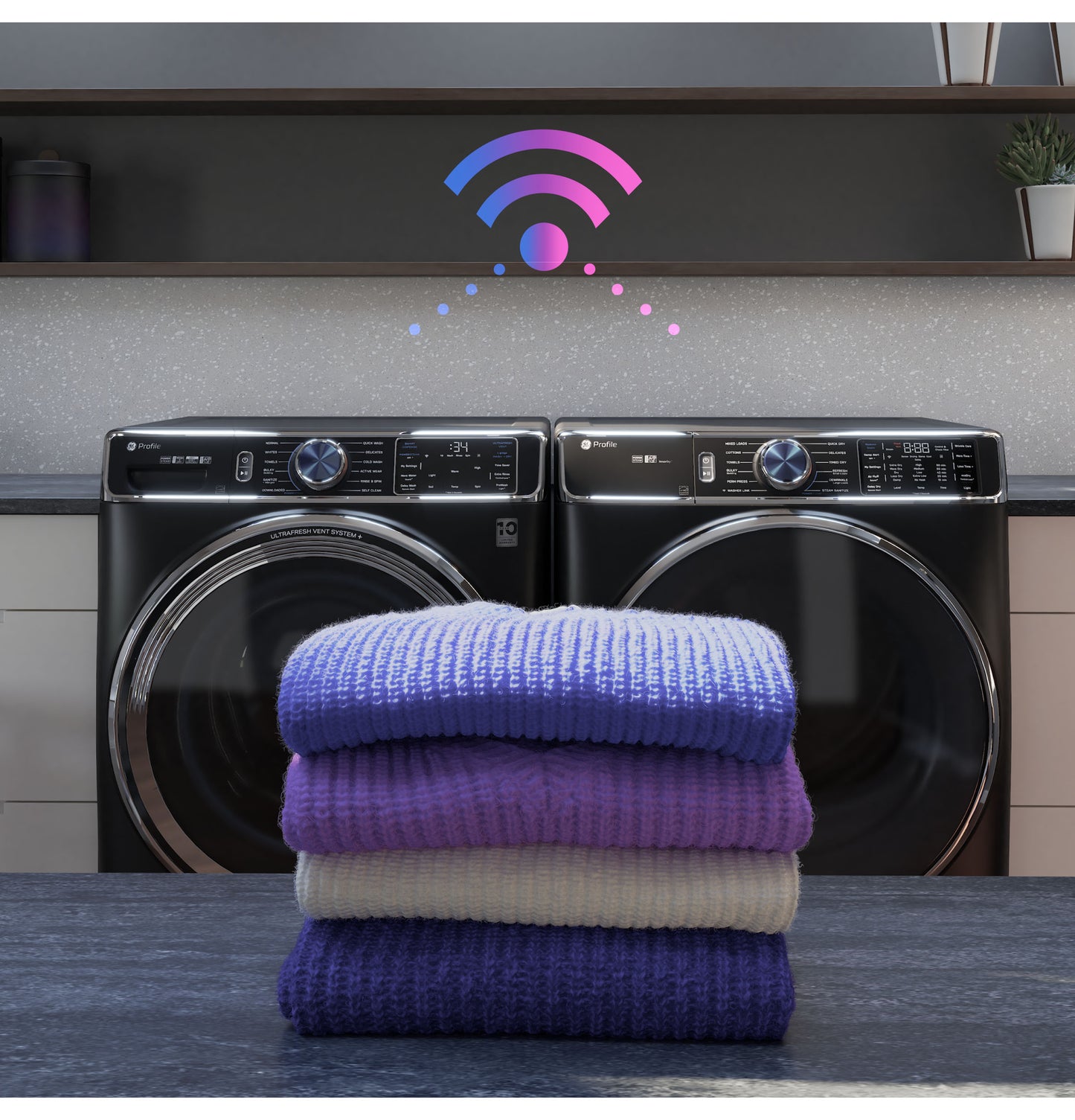 Stack of folded sweaters in front of black smart front load electric washer and dryer with Wi-Fi symbol above