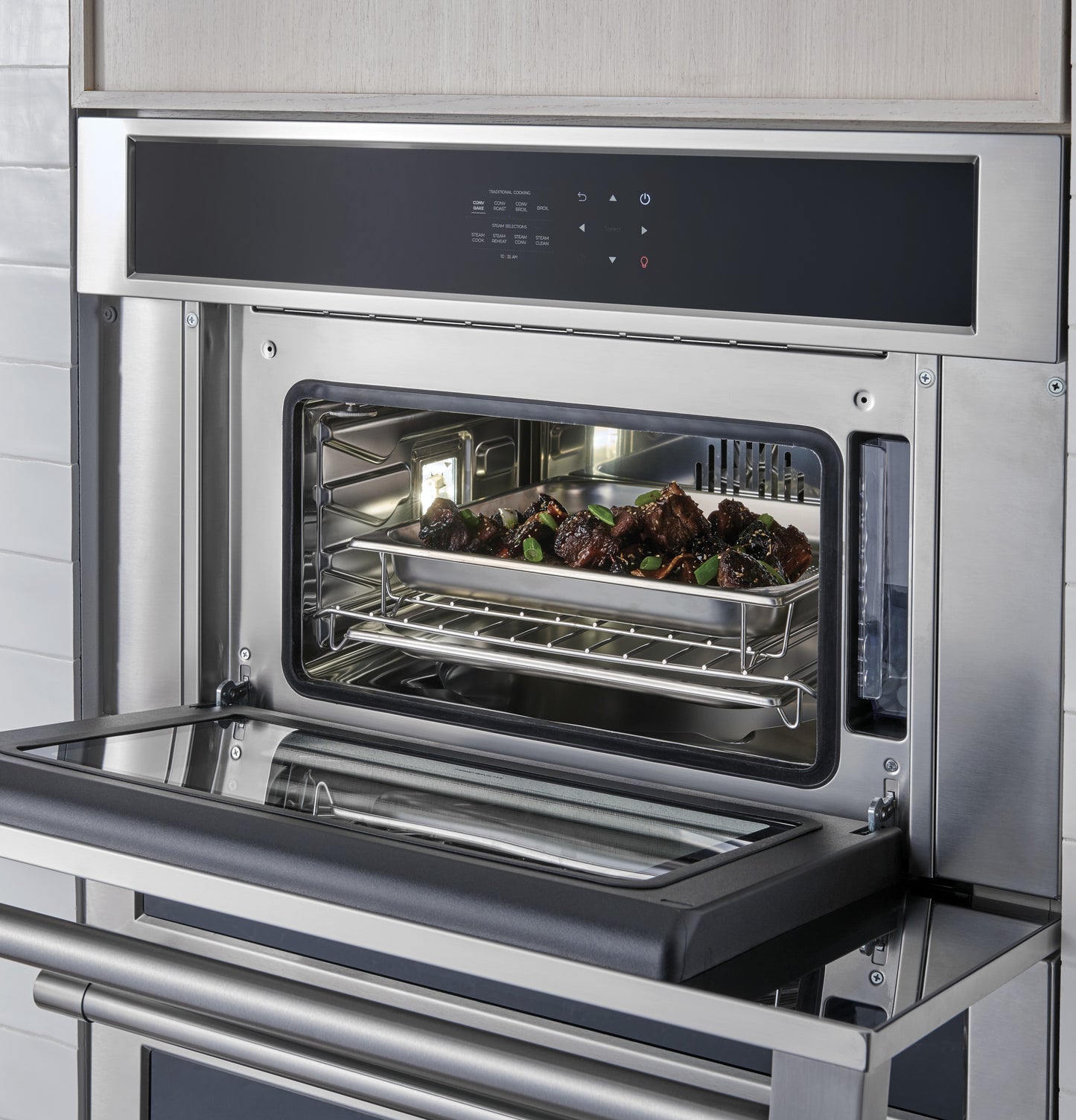 Built-in stainless steel steam oven with digital control panel cooking meat tray in modern kitchen appliances collection