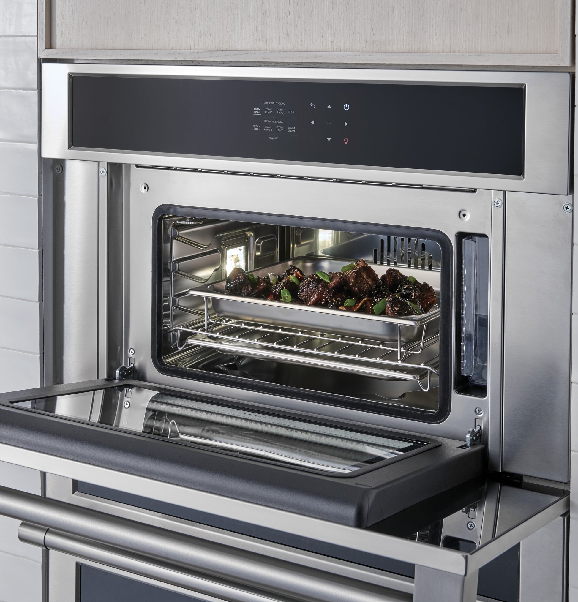 Built-in stainless steel steam oven with digital control panel cooking meat tray in modern kitchen appliances collection