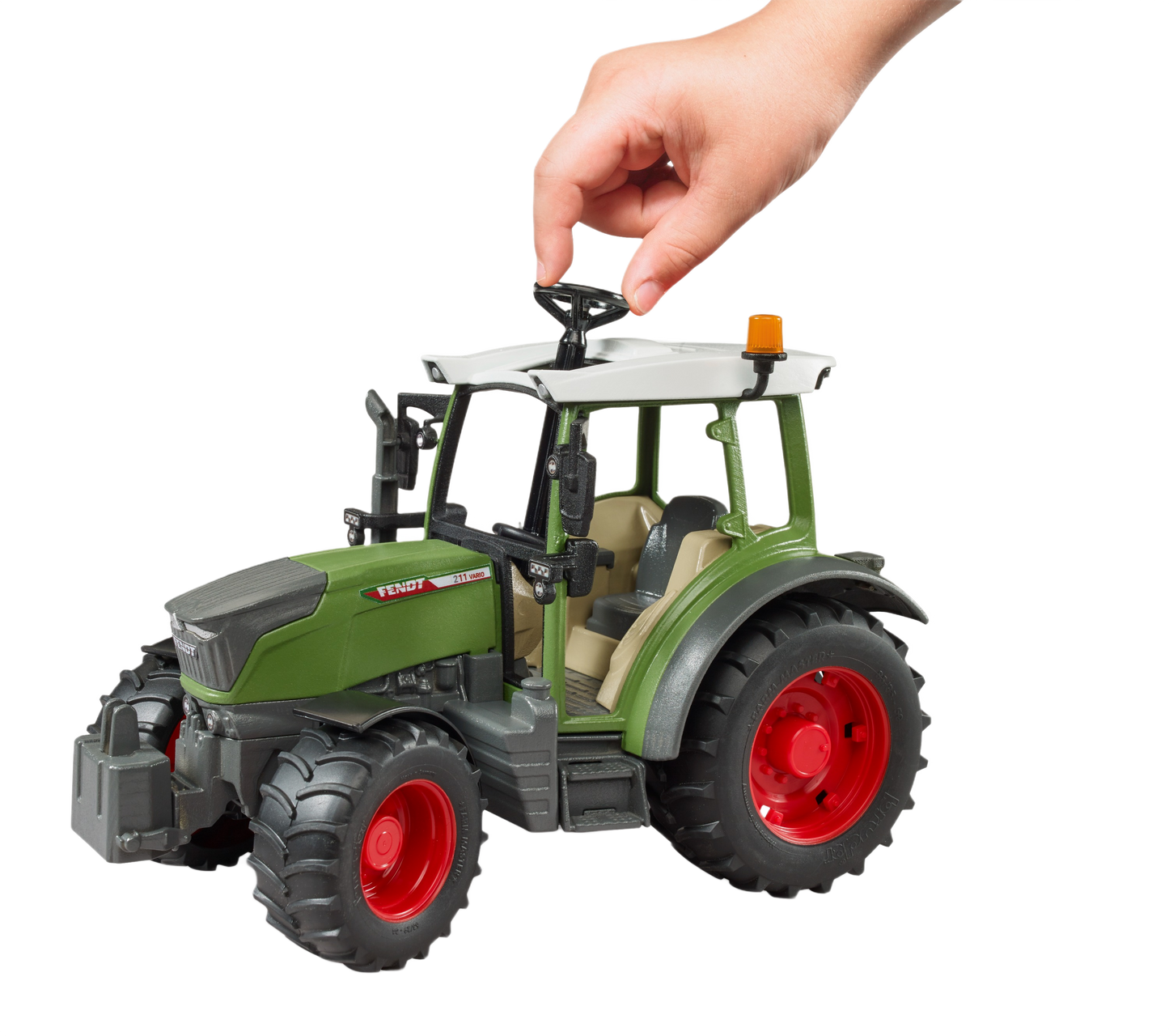 Hand turning the steering wheel of a green Bruder Fendt Vario 211 tractor model with red wheels for tools and home improvement fans