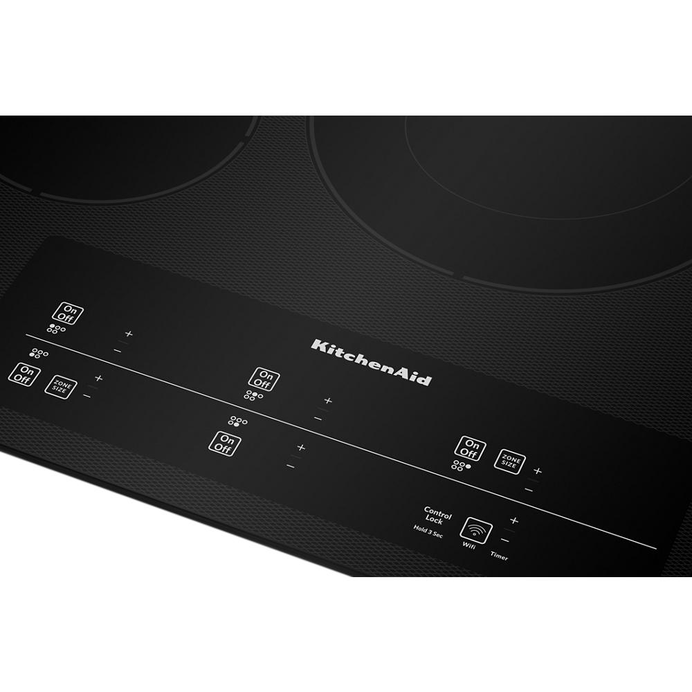 Close-up of black electric cooktop touch-activated control panel with power and timer settings from KitchenAid Cooktops collection
