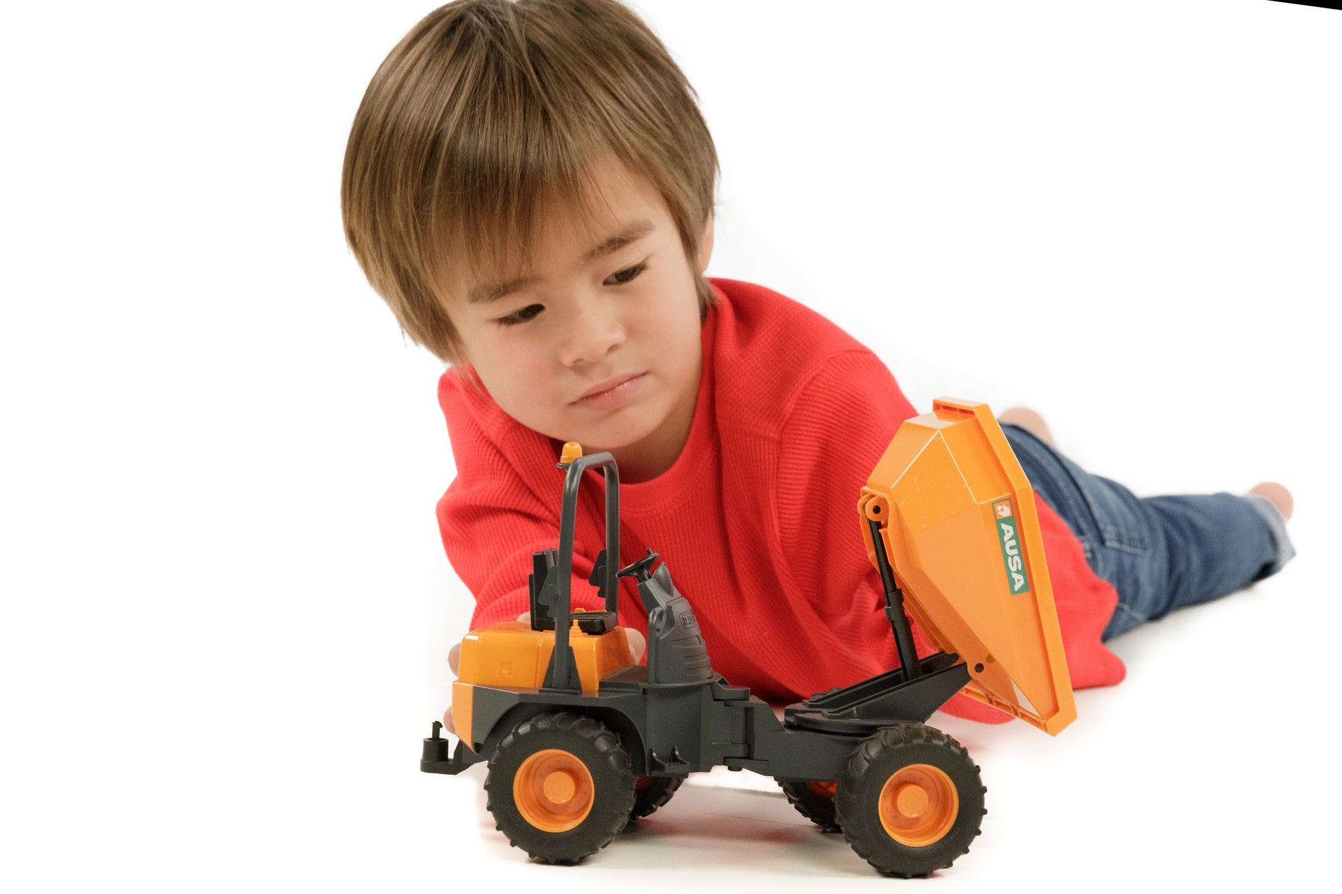 Young boy in red shirt playing with Bruder Ausa Minidumper toy designed for imaginative outdoor play
